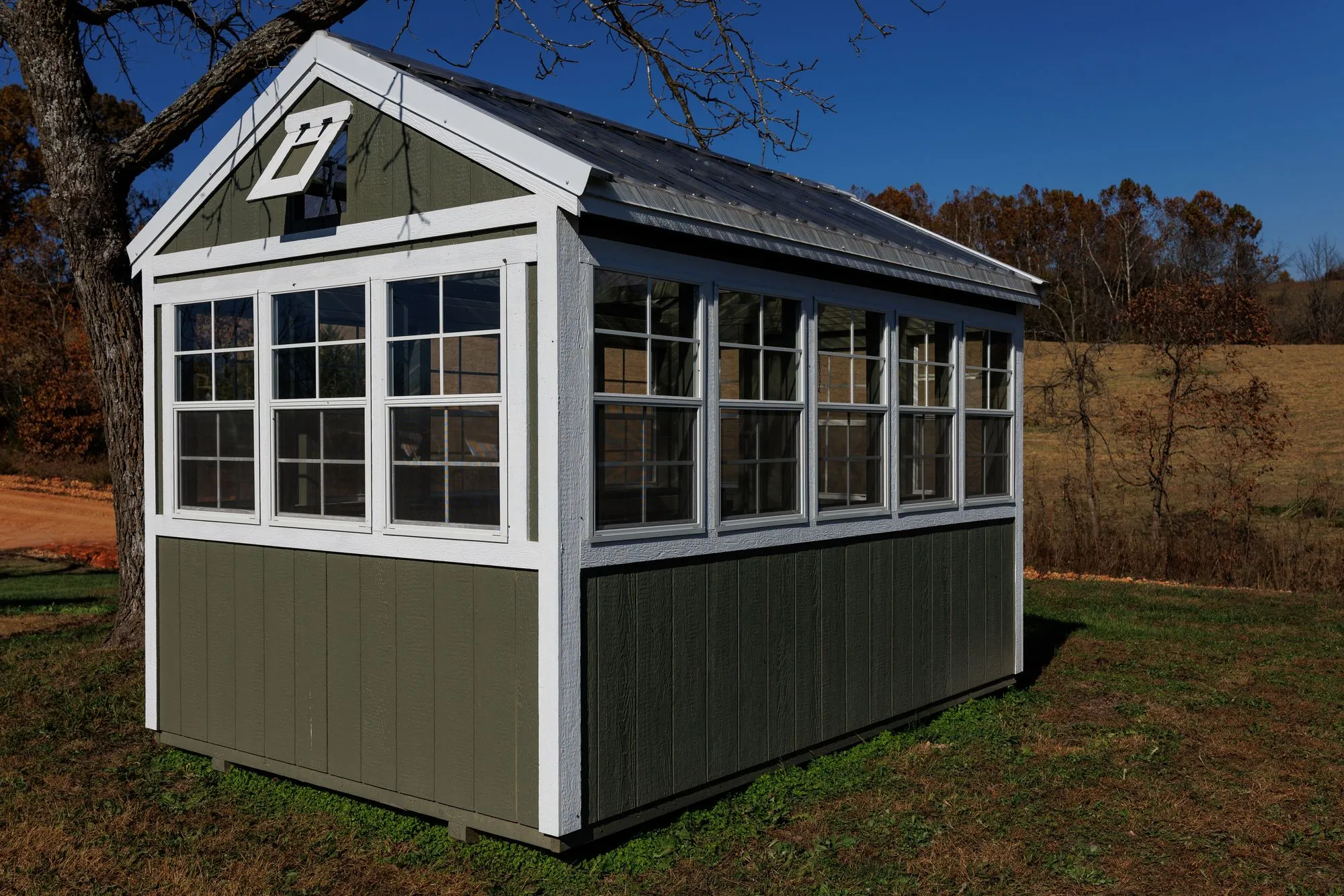 Greenhouse with olive-green siding, white trim, windows all round