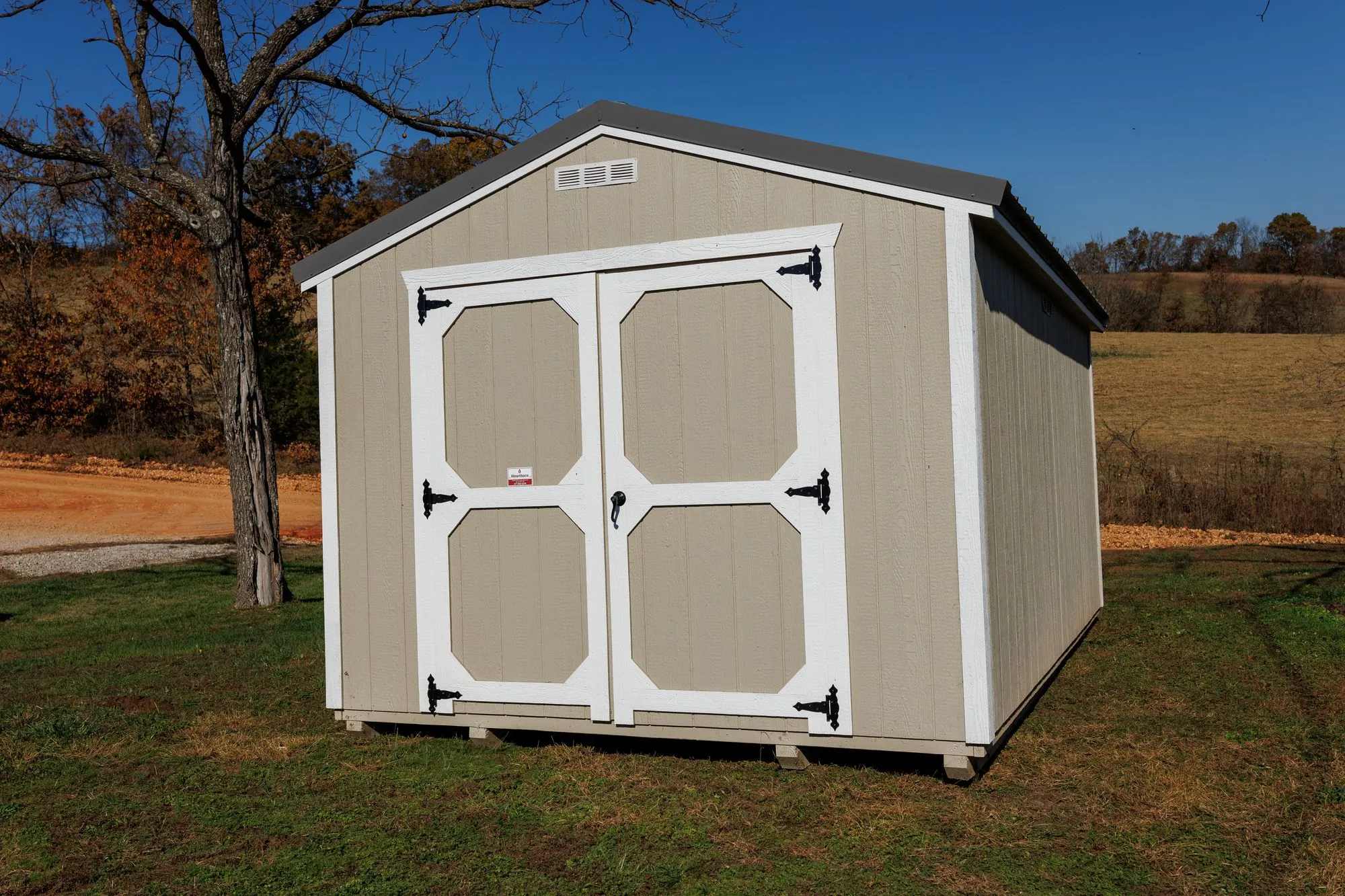 Utility Shed with taupe siding, white trim, charcoal roof, white octagon-panel doors