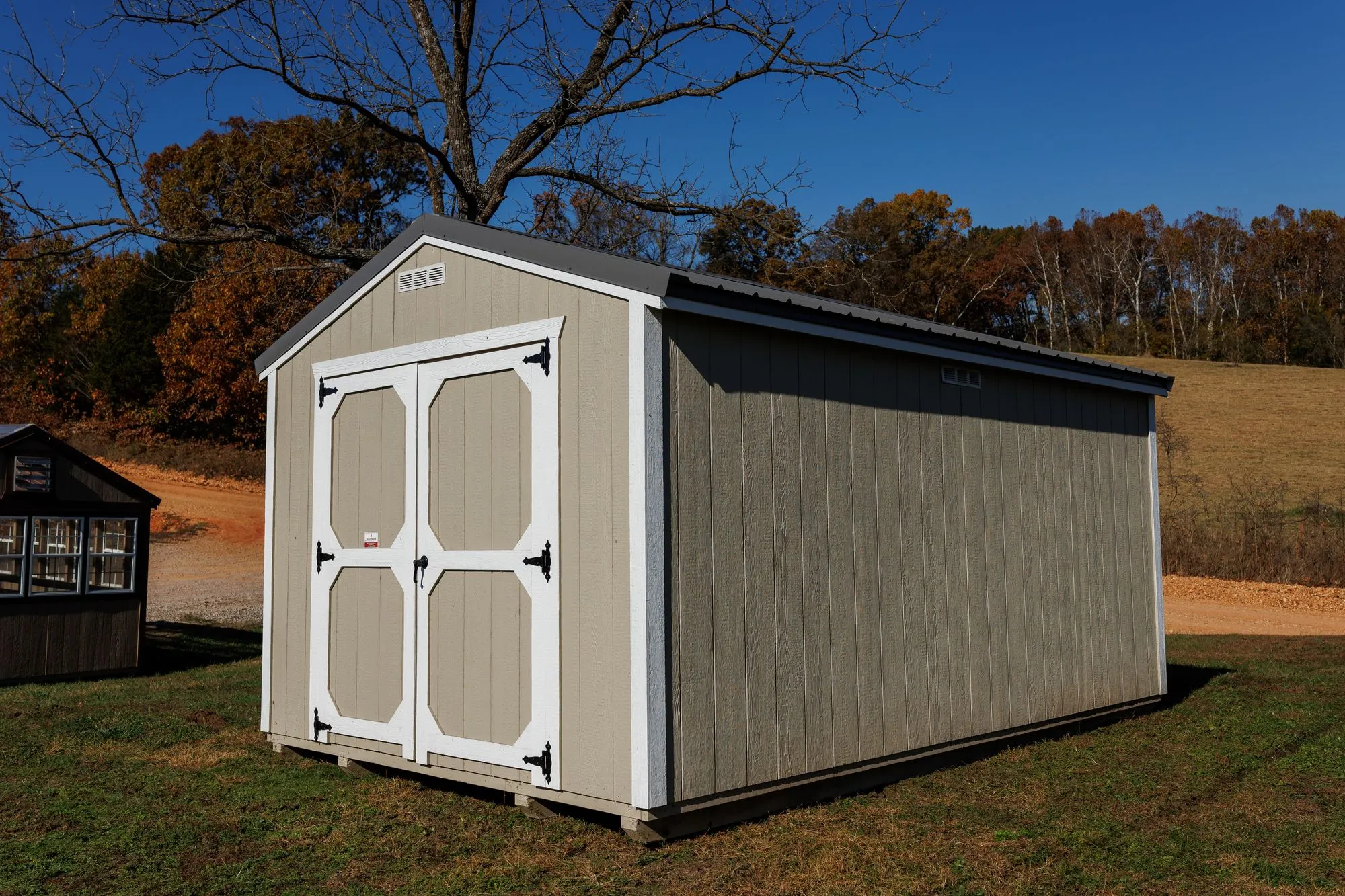 Utility Shed with taupe siding, white trim, charcoal roof, white octagon-panel doors