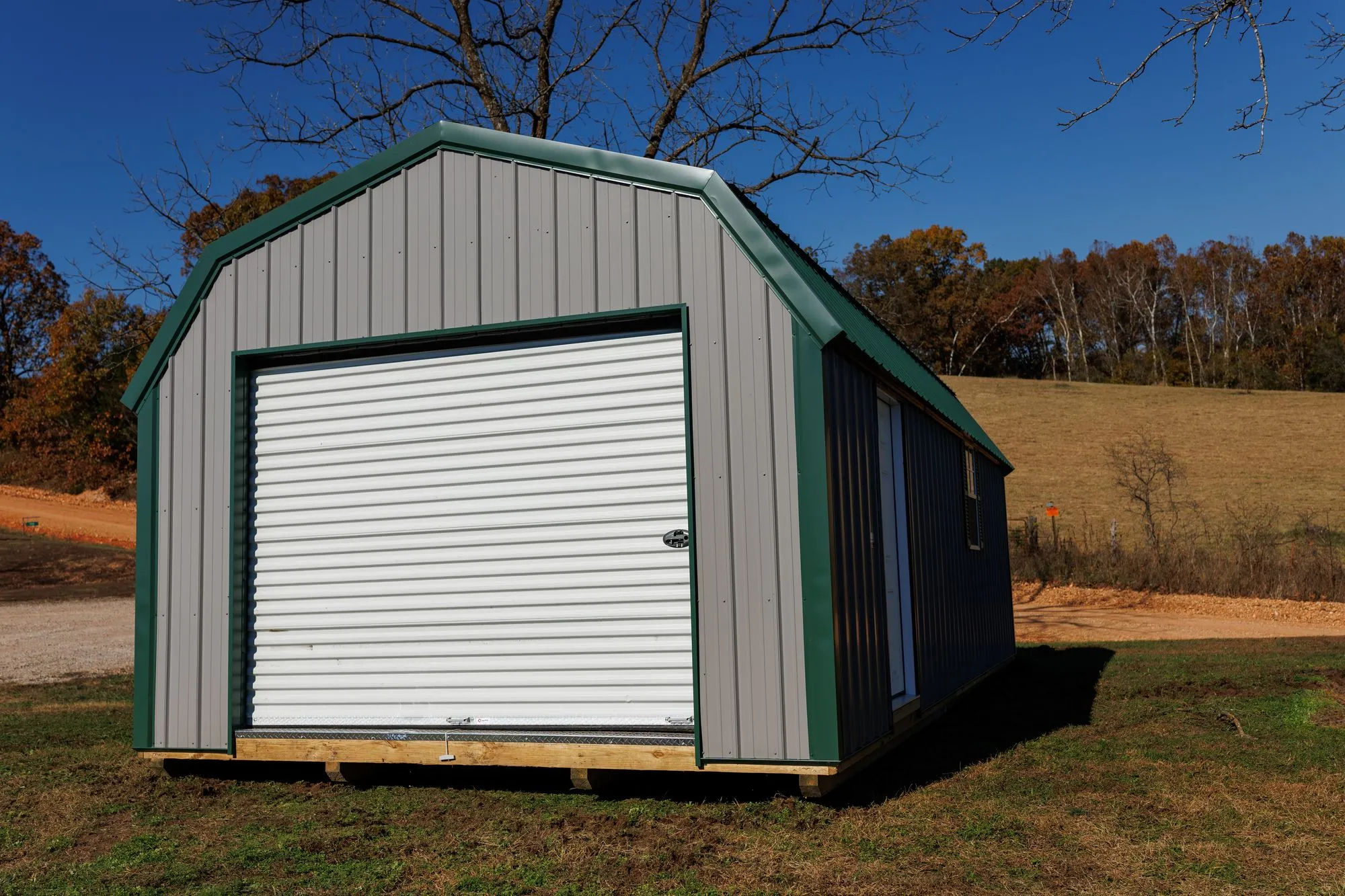 Lofted Garage with gray metal siding with green trim and roof