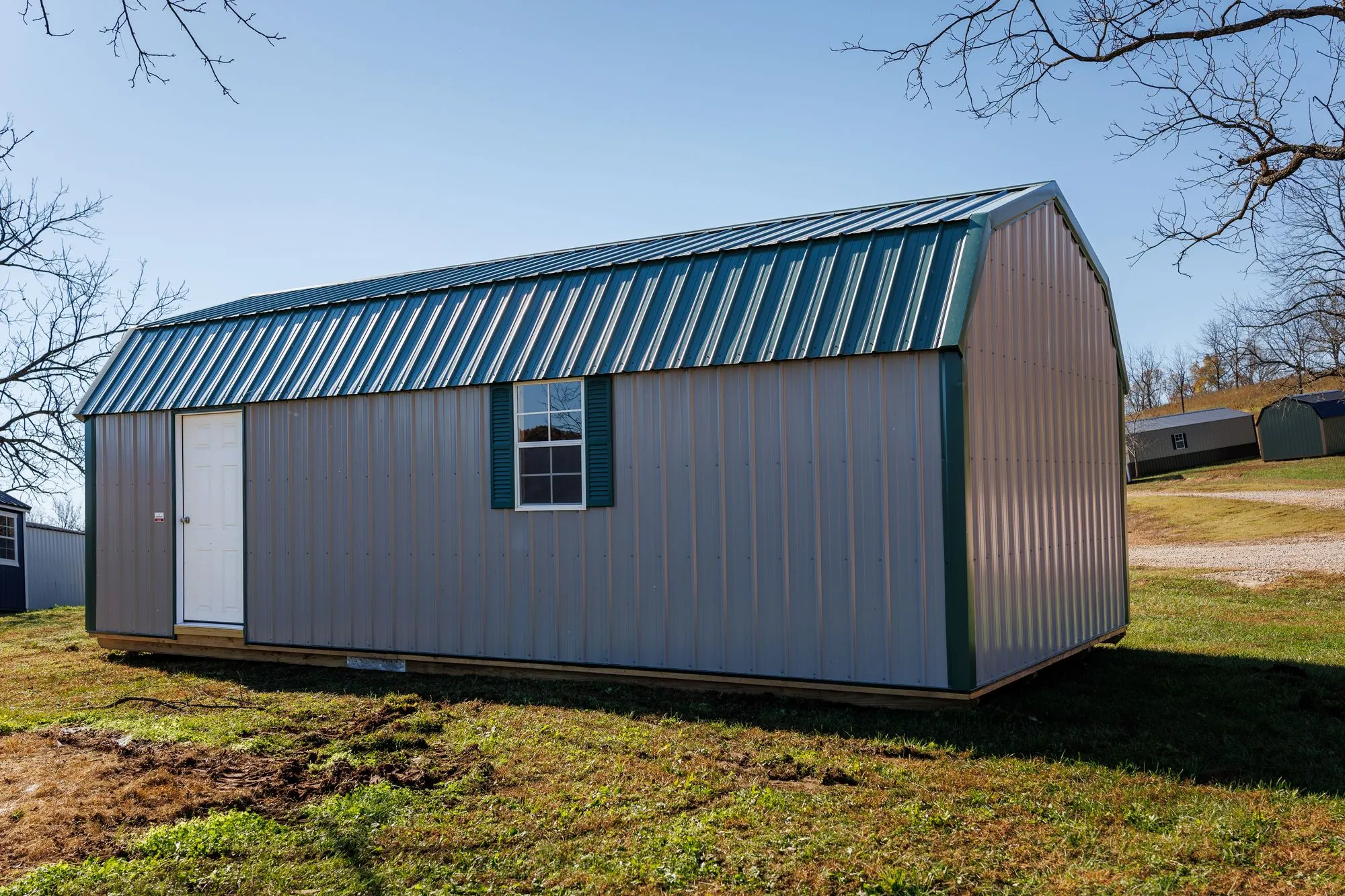 Lofted Garage with gray metal siding with green trim and roof