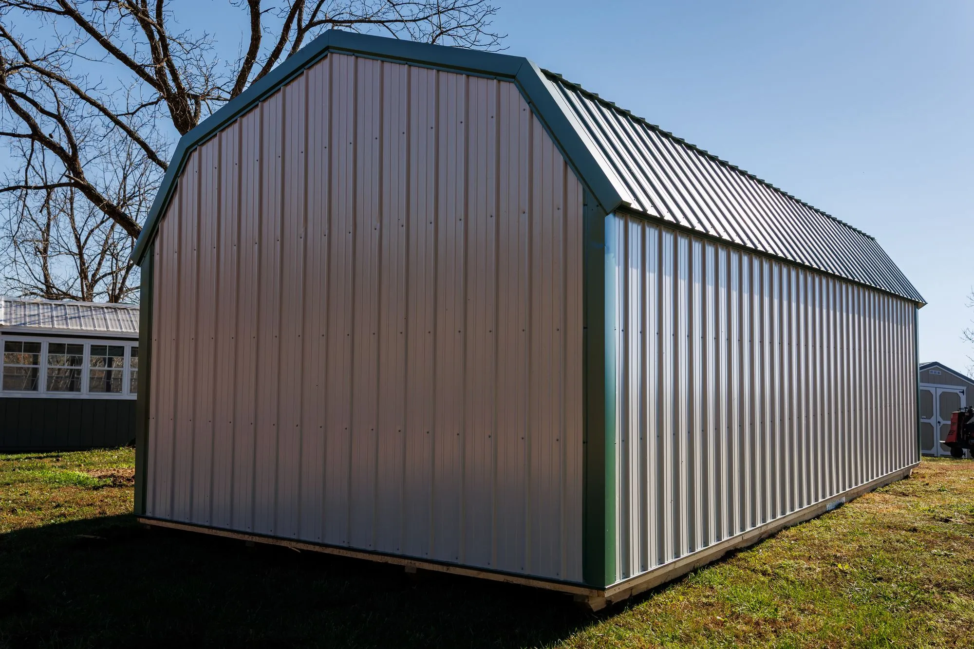 Lofted Garage with gray metal siding with green trim and roof