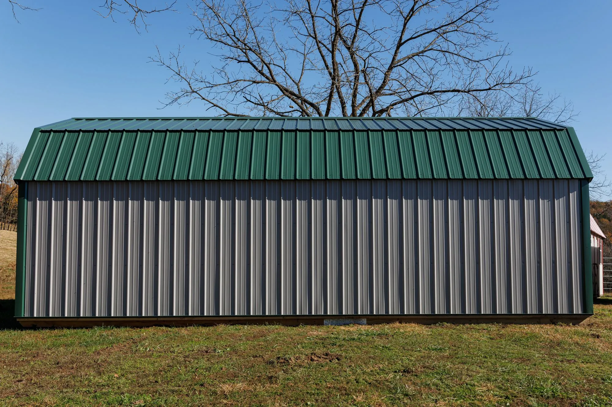 Lofted Garage with gray metal siding with green trim and roof