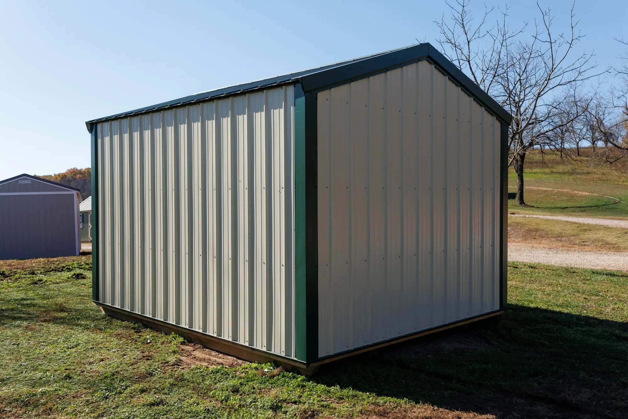 Utility Shed with ivory metal siding with green trim and roof, green X-braced doors