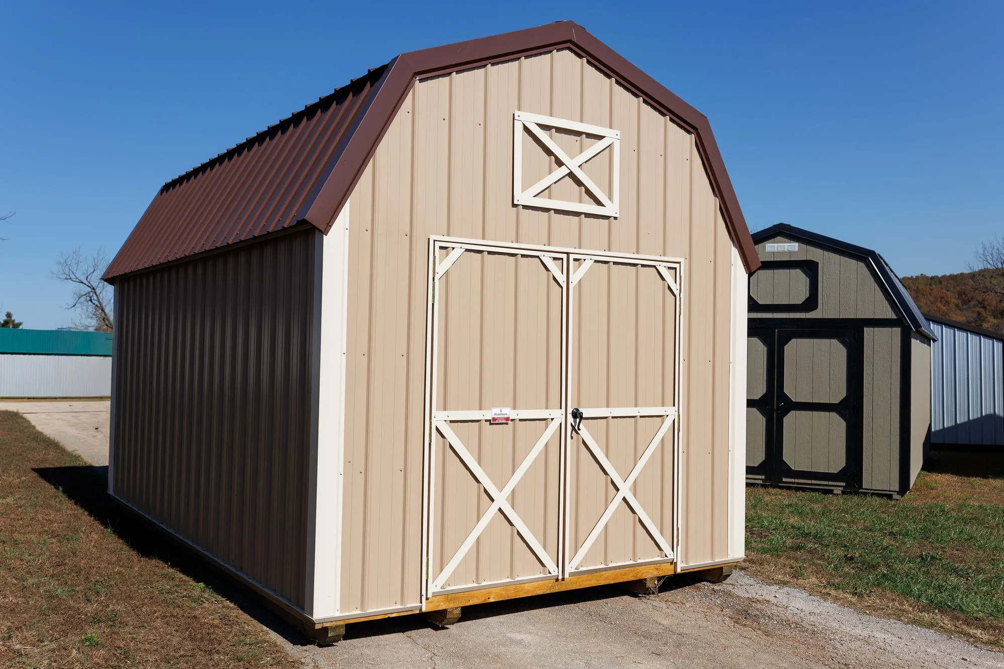 Lofted Barn with tan metal siding, white trim, brown roof