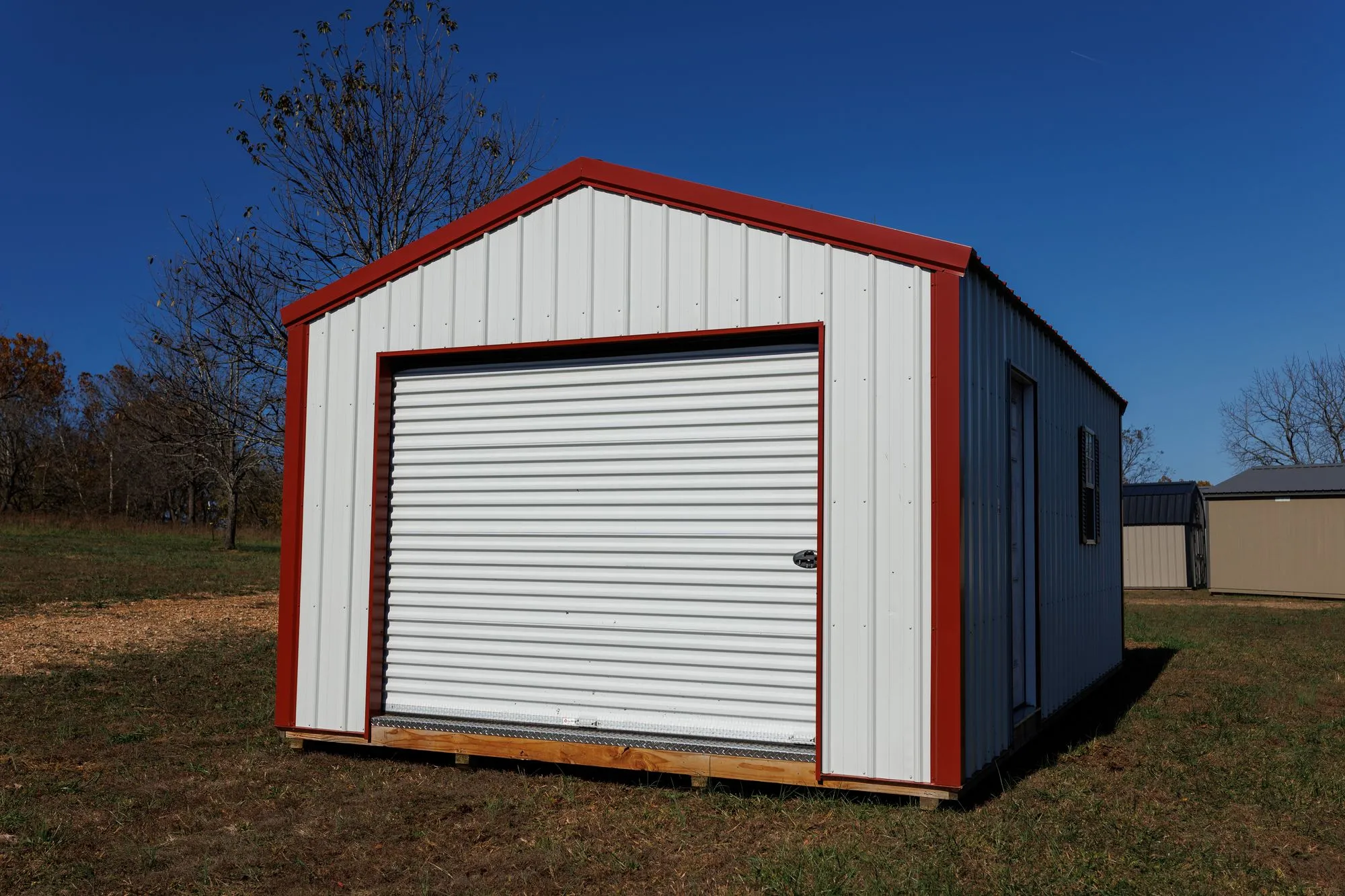 Portable Garage with white metal siding with red trim