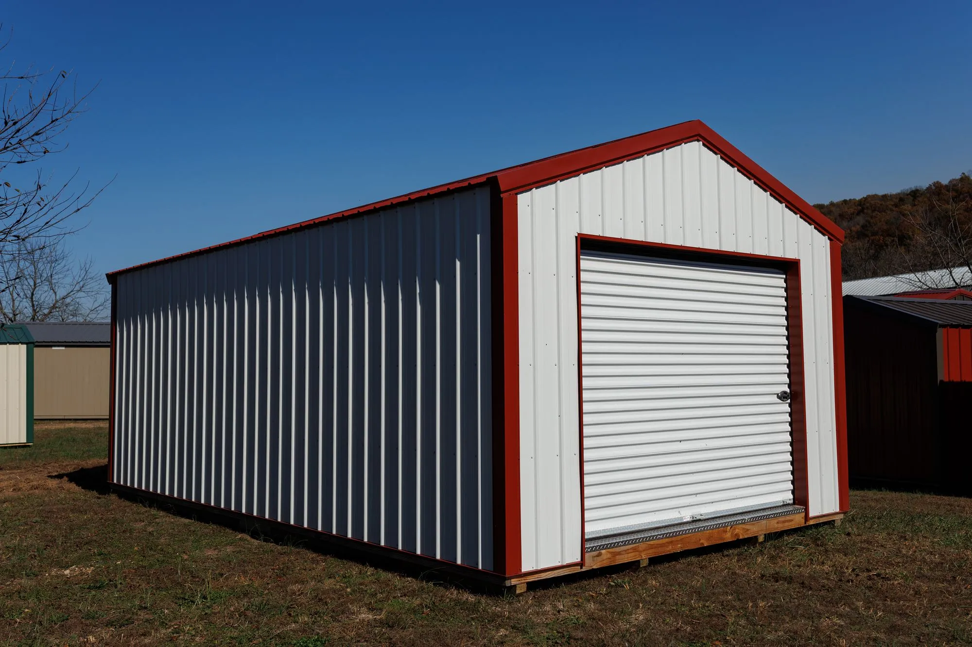 Portable Garage with white metal siding with red trim