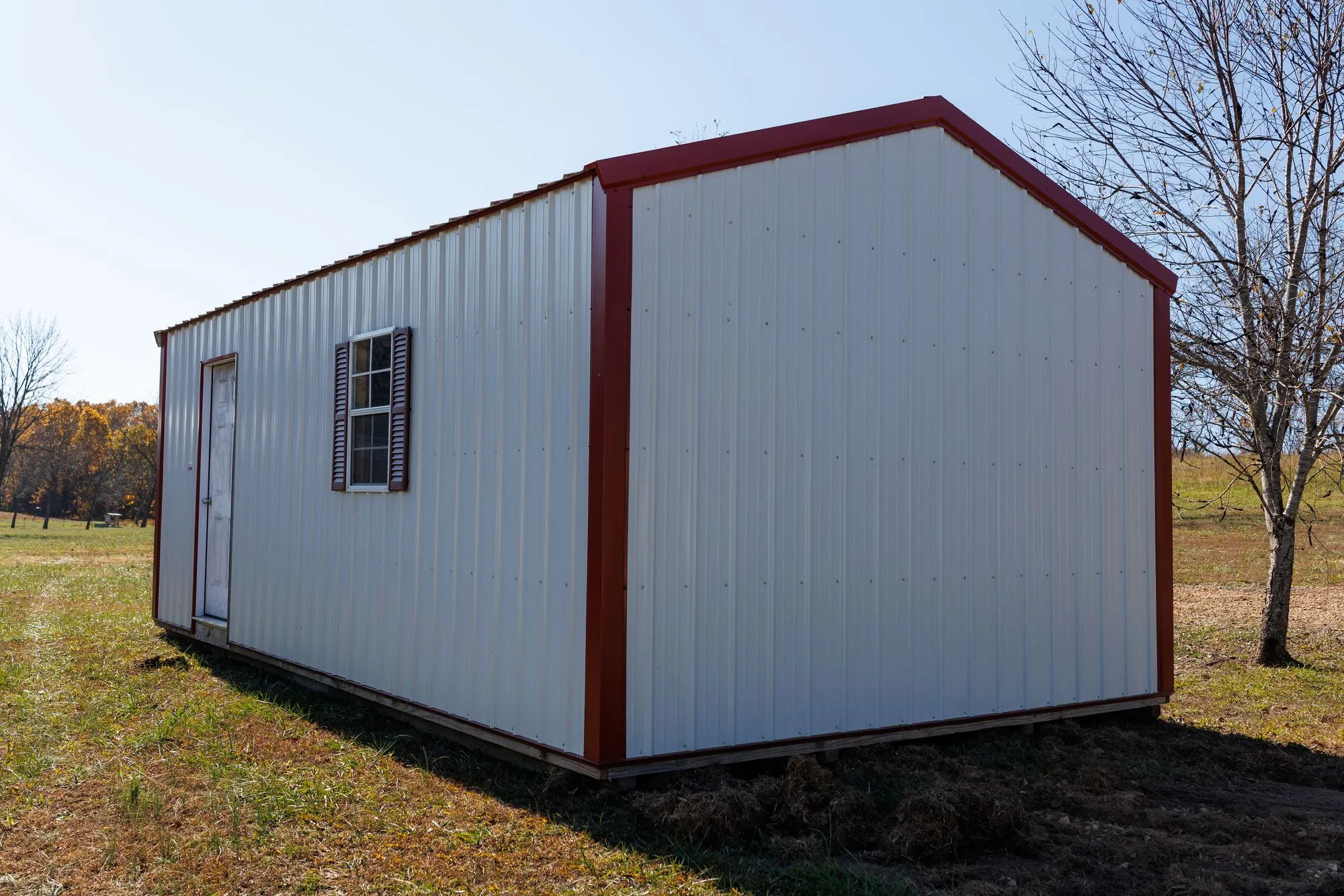 Portable Garage with white metal siding with red trim