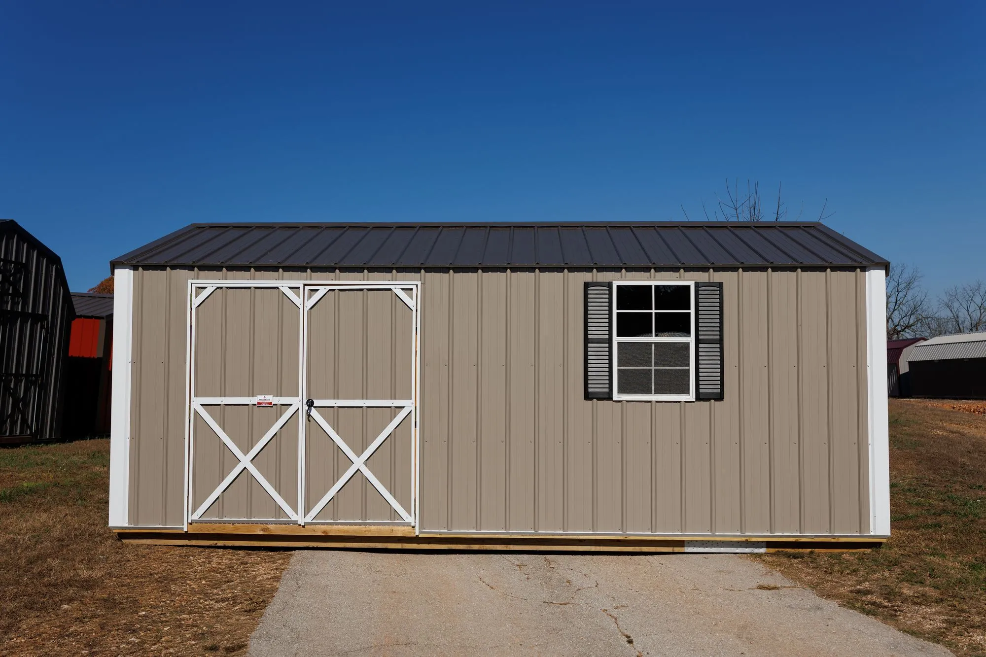 Garden Shed with clay metal siding, white trim, black roof, white X-braced doors