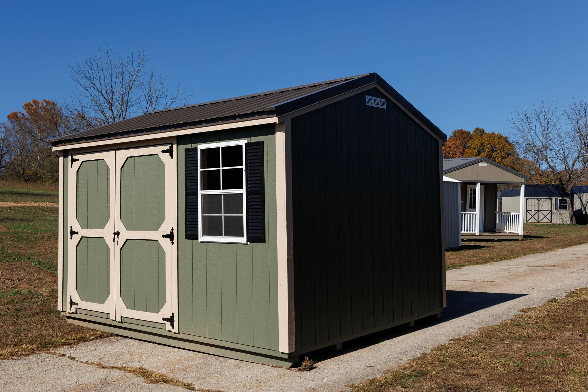 Garden Shed with sage siding, cream trim, black roof, cream-framed doors