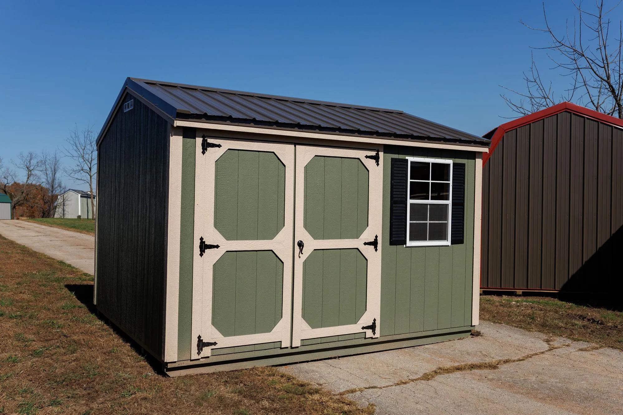 Garden Shed with sage siding, cream trim, black roof, cream-framed doors