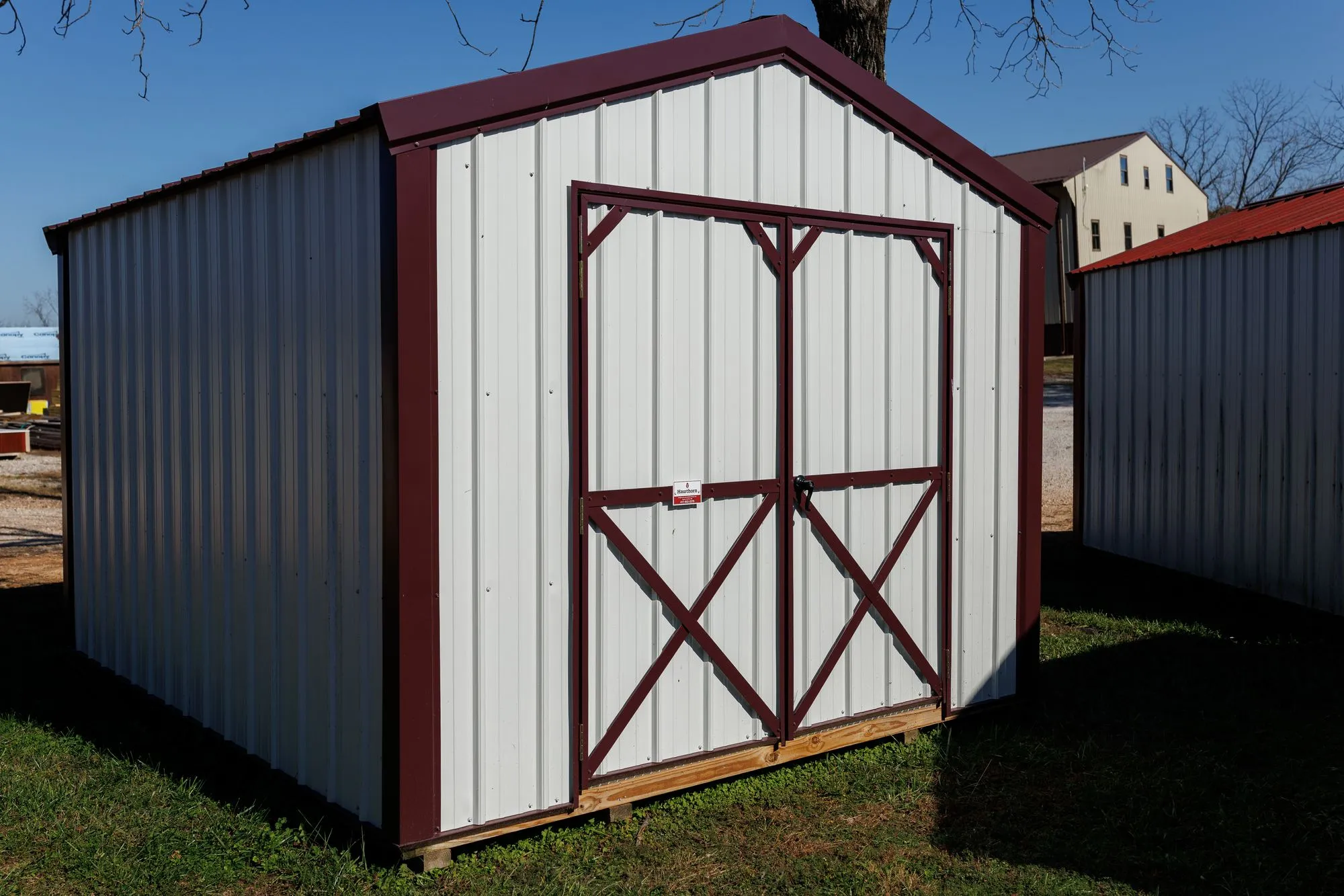 Utility Shed with white metal siding, burgundy trim and roof