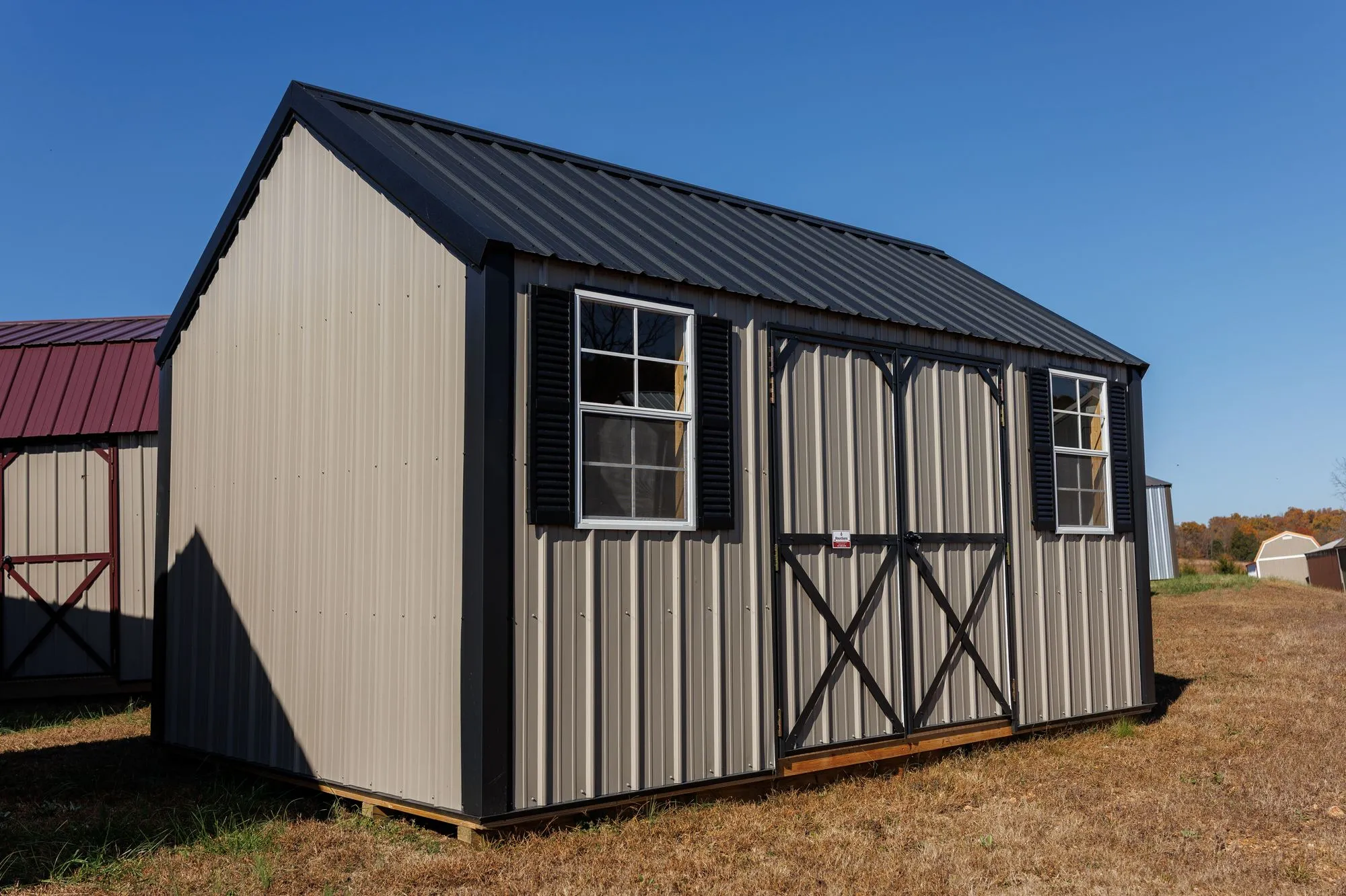 Lofted Garden Shed with clay metal siding, black trim and roof, black X-braced doors, two windows