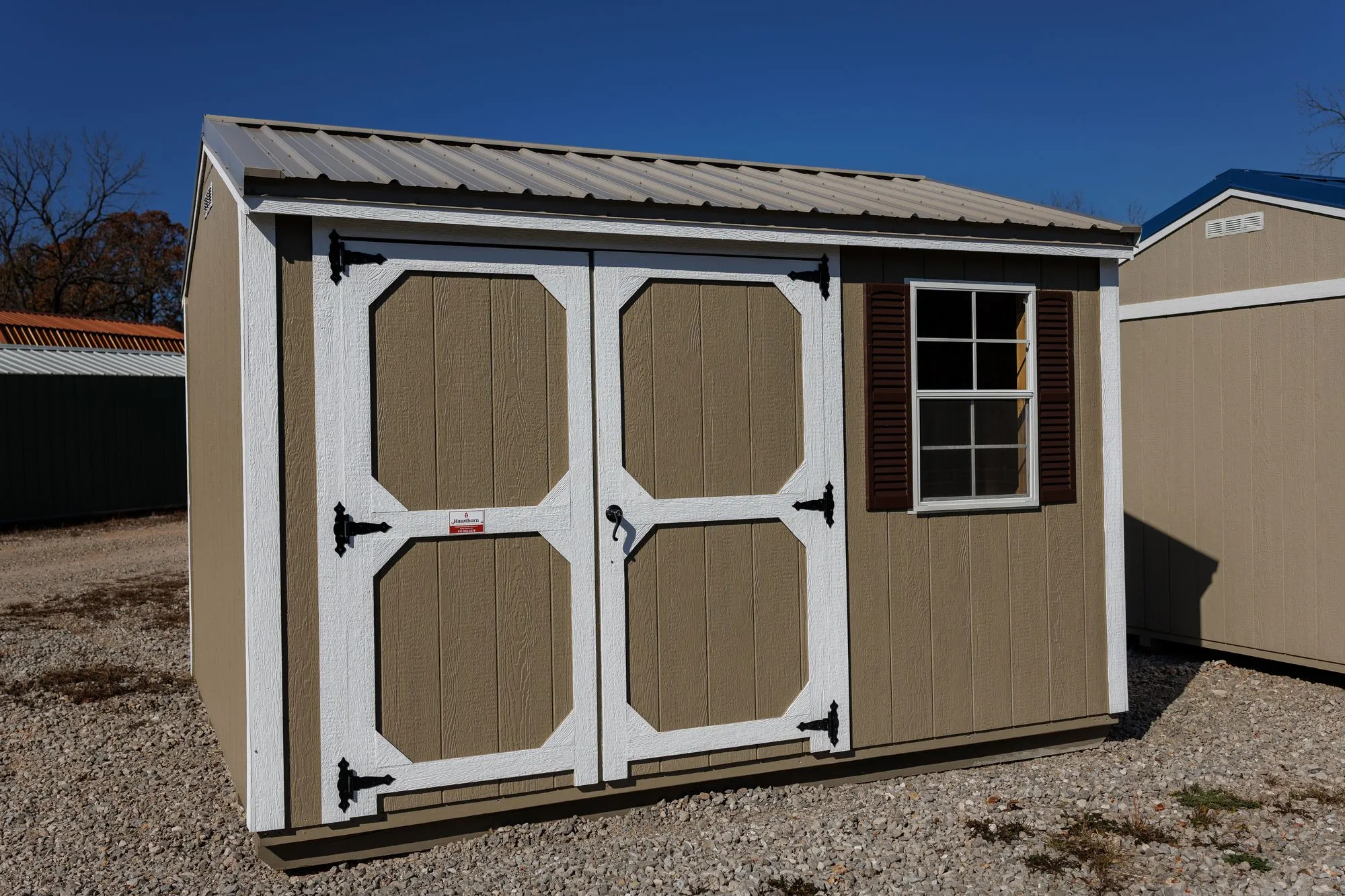 Garden Shed with clay siding, white trim, galvalume roof, white-framed doors
