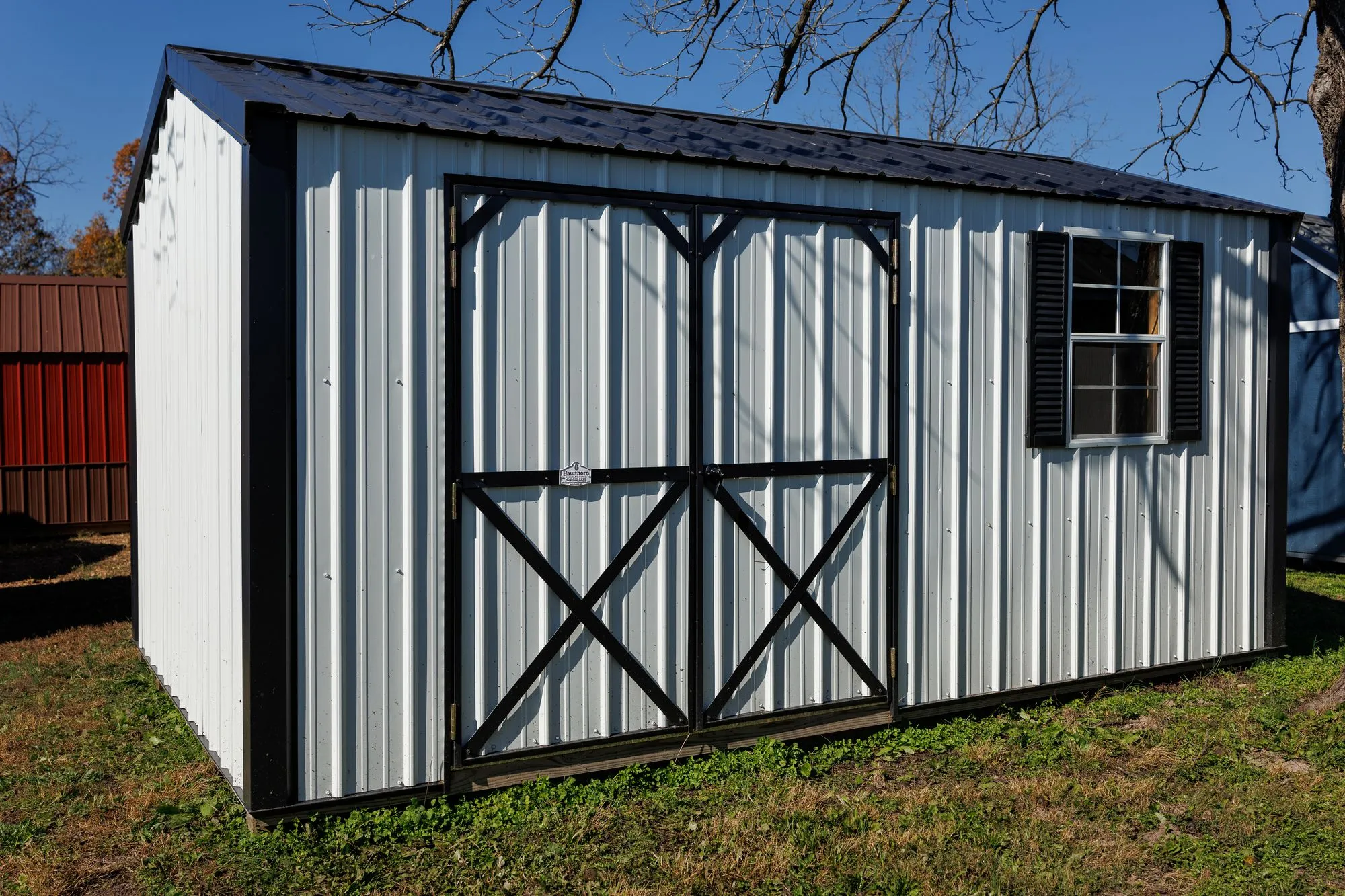 Garden Shed with white metal siding, black trim, black X-braced doors
