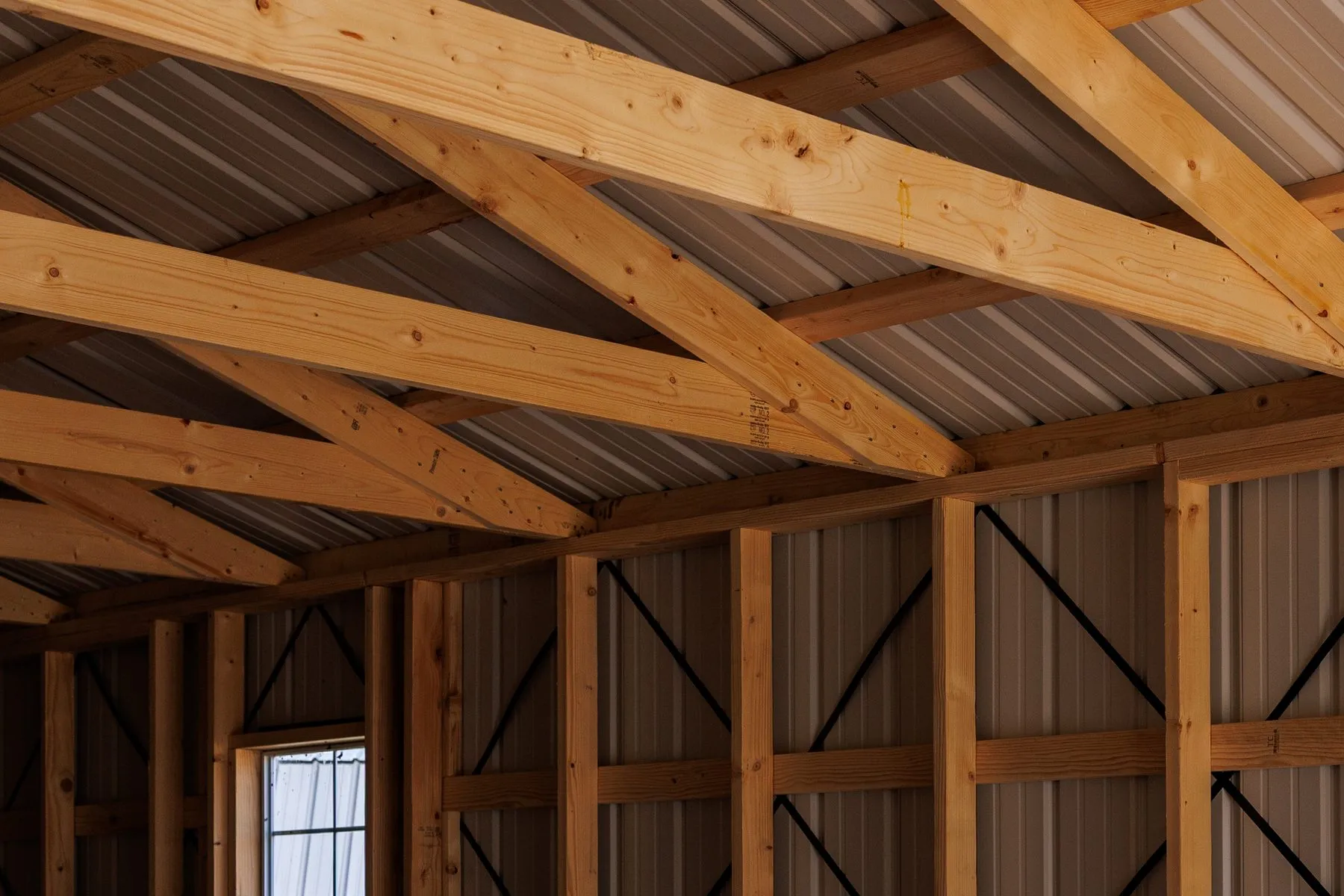 Wood rafters and truss joints under the metal roof of a building