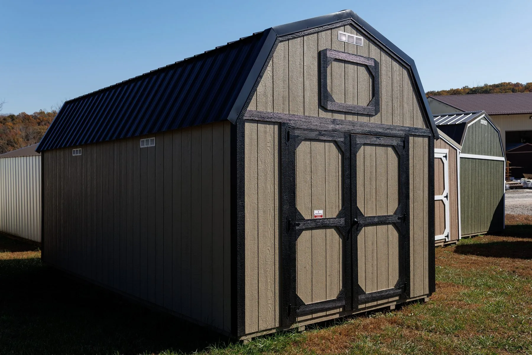 A lofted barn in tan LP SmartSide siding with black trim and black-framed doors